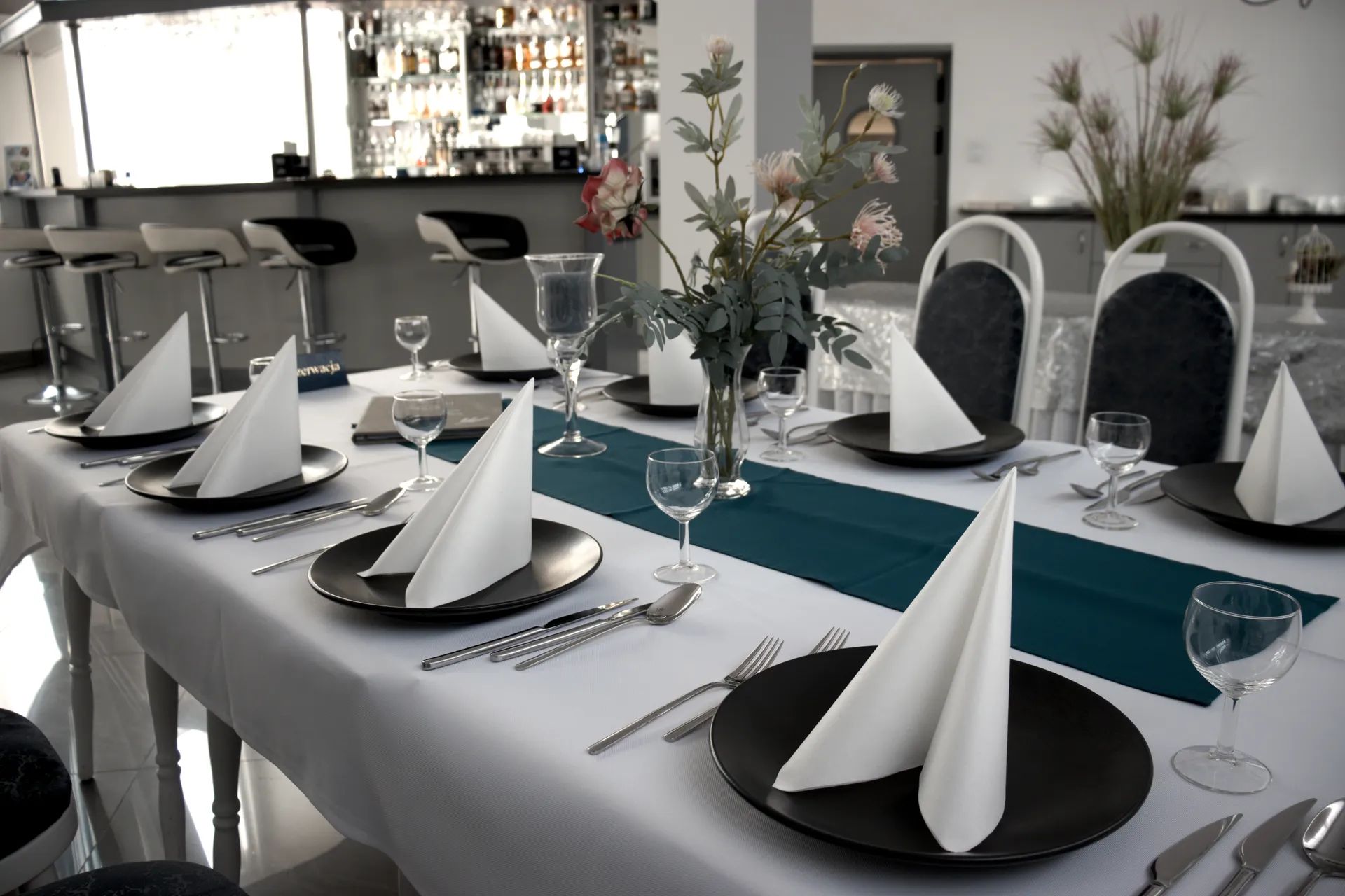 Elegancko nakryty stół z czarną zastawą — restauracja Złoty Łan